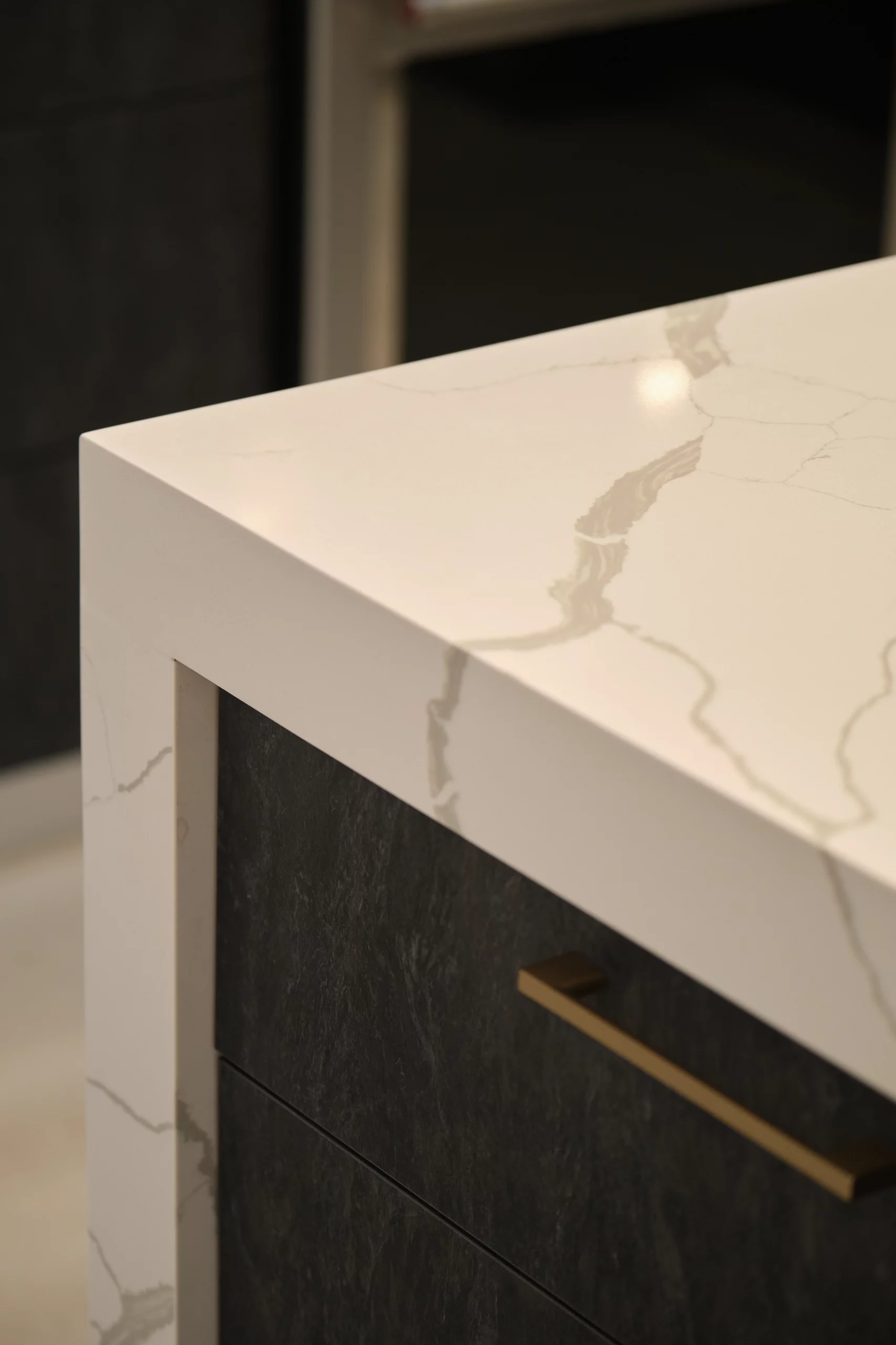 Close-up of a white quartz countertop with veining over dark cabinetry during a kitchen remodeling project.