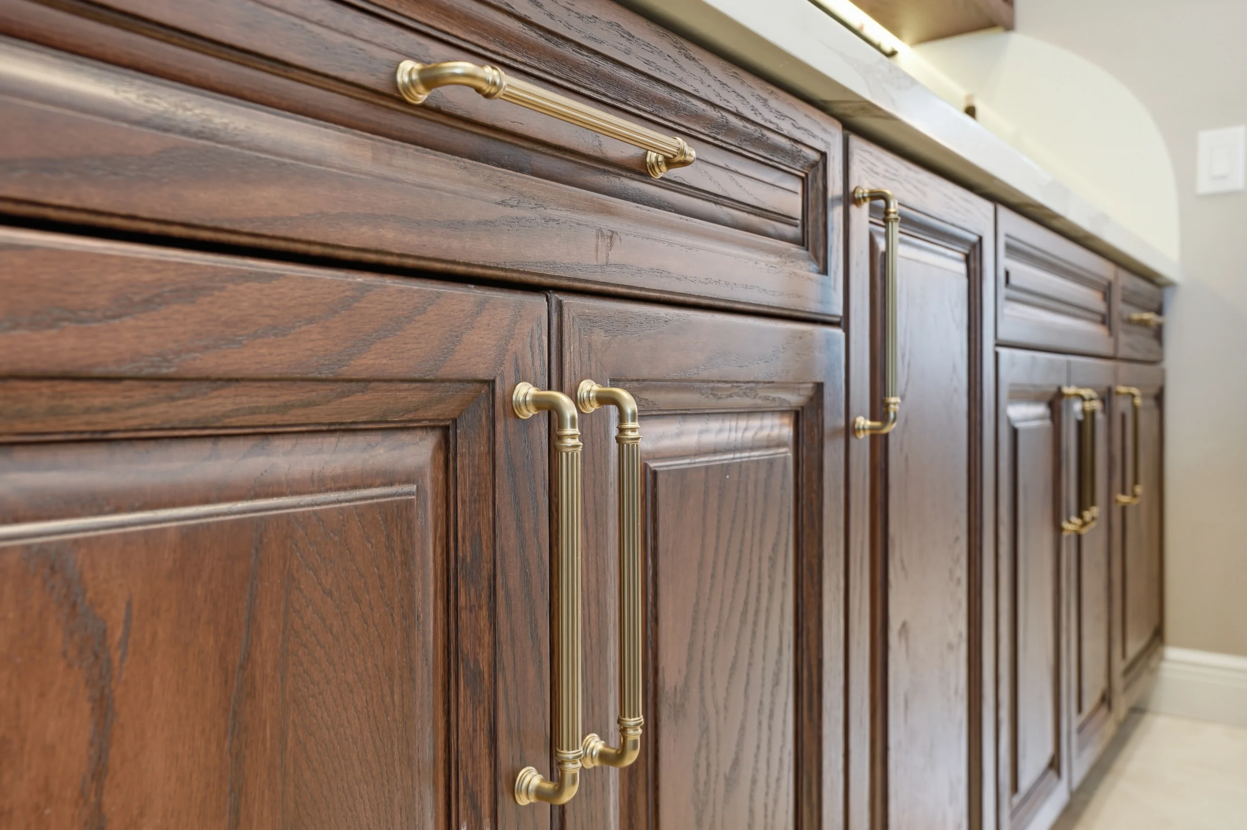 Close-up of custom dark wood cabinetry with brass hardware during a professional wet bar installation in Plantation, FL.