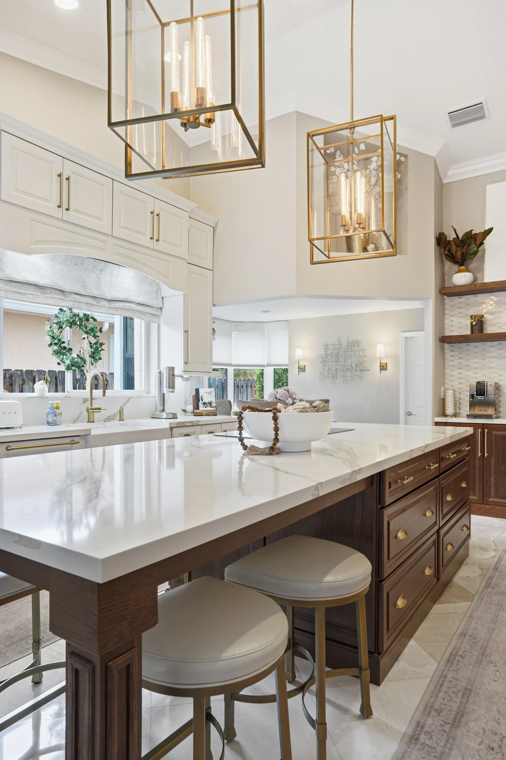 Elegant kitchen remodeling in Plantation FL featuring a marble-topped island, custom dark wood cabinetry, and brass fixtures.