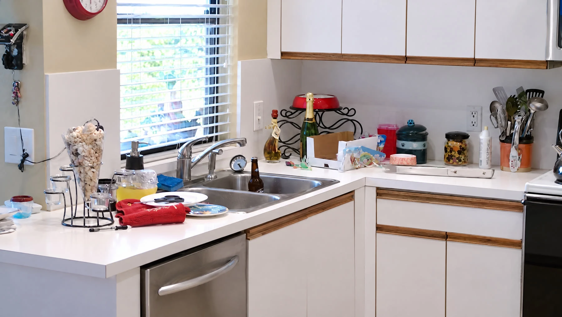 Quartz vs Granite vs Marble: Best Countertop for Plantation Kitchens 6 Gonzalez kitchen before the remodel, with white laminate counters, flat-panel cabinets and a cluttered sink area